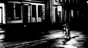 Einsam steht ein Fahrrad an einer regennassen Straße